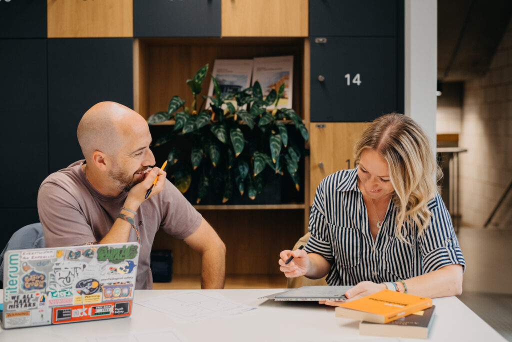 Tom and Jade smiling and working with laptop